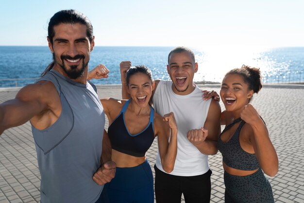 Group of people taking selfie while exercising together outdoors
