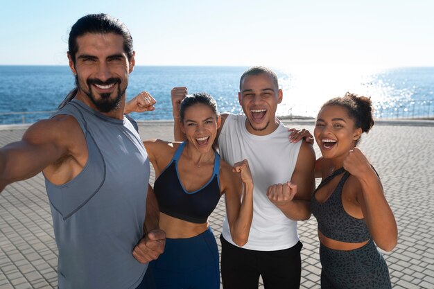 group of people taking selfie while exercising together outdoors