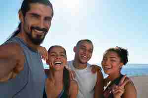 Free photo group of people taking selfie while exercising together outdoors