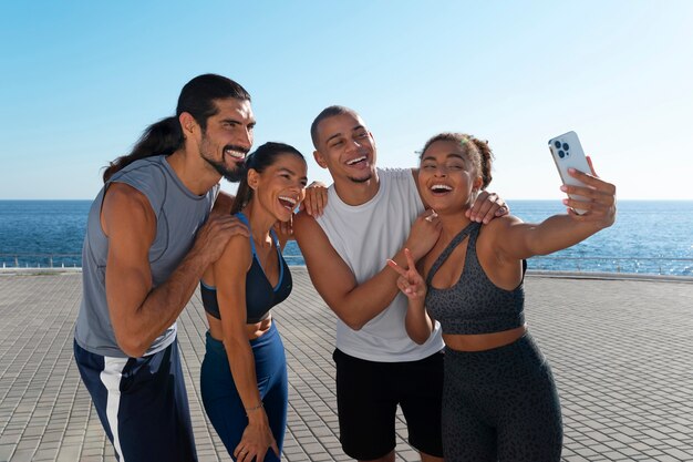 Group of people taking selfie while exercising together outdoors