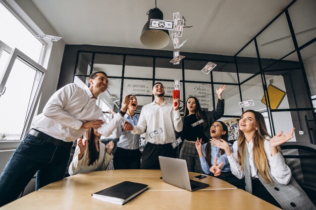 Group of people throwing money in an office