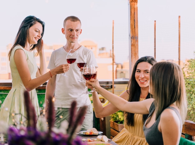 Group of people toasting at rooftop party