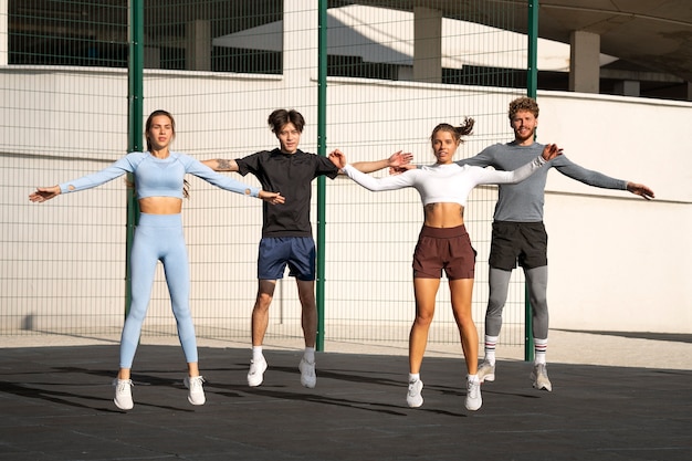 Free photo group of people working out together outdoors