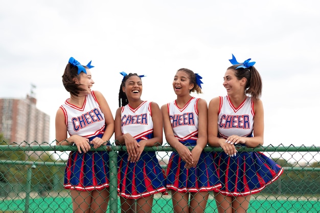 Group of pretty teenager cheerleaders in cute uniform