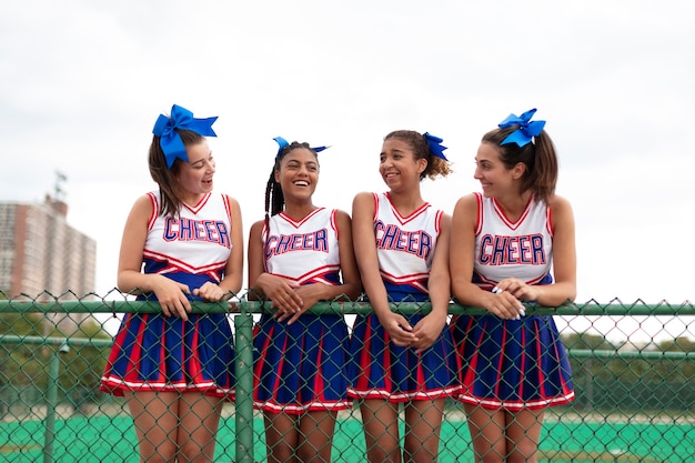 Group of pretty teenager cheerleaders in cute uniform