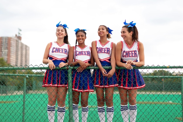 Group of pretty teenager cheerleaders in cute uniform