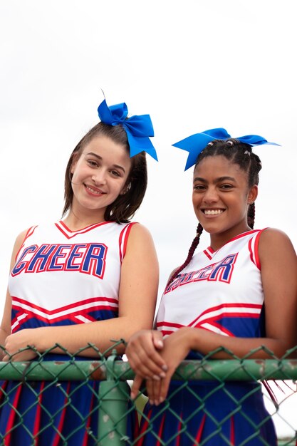 Group of pretty teenager cheerleaders in cute uniform