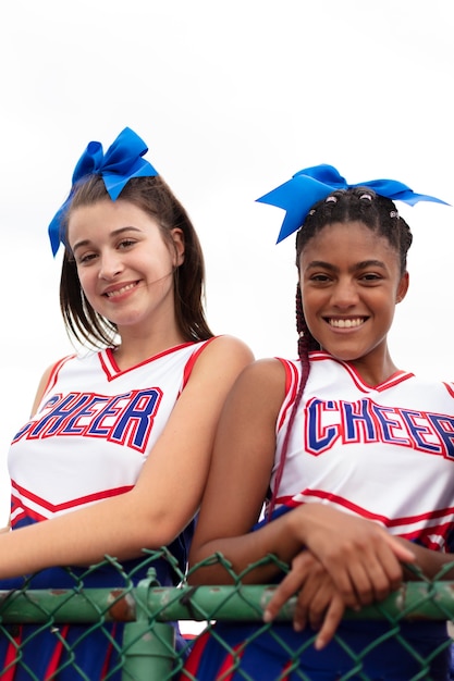 Group of pretty teenager cheerleaders in cute uniform