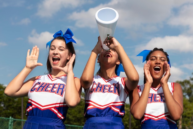 Group of pretty teenagers in cheerleader uniforms