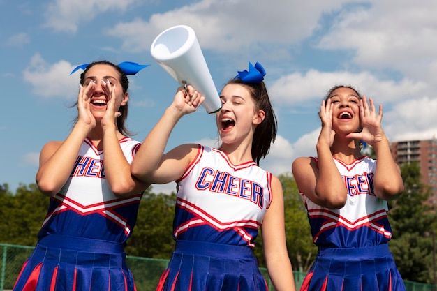 Free photo group of pretty teenagers in cheerleader uniforms