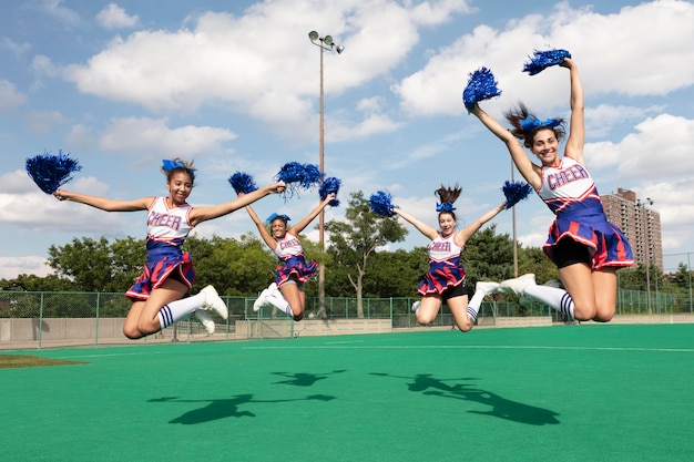 Free photo group of pretty teenagers in cheerleader uniforms