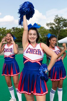 Group of pretty teenagers in cheerleader uniforms