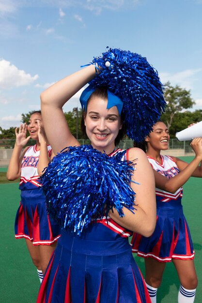 Group of pretty teenagers in cheerleader uniforms