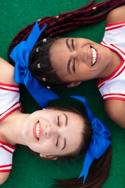 Group of pretty teenagers in cheerleader uniforms