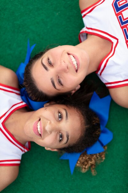 Group of pretty teenagers in cheerleader uniforms