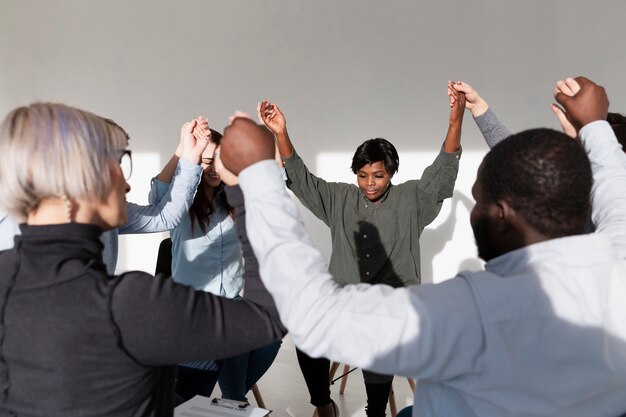 Group of rehab patients raising their hands