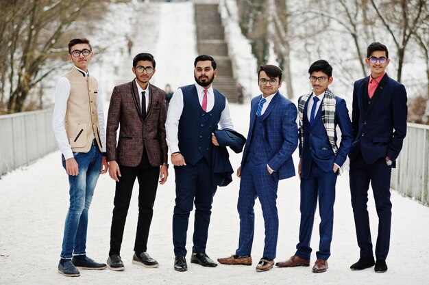 ヨーロッパで冬の日に屋外でポーズをとったスーツを着た6人のインド人ビジネスマンのグループ