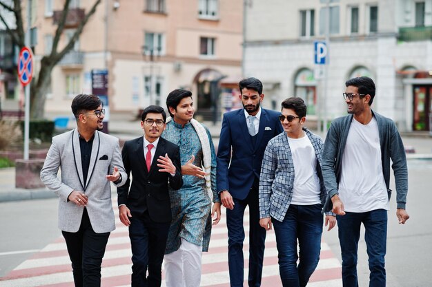 Group of six south asian indian mans in traditional casual and business wear walking at crosswalk together