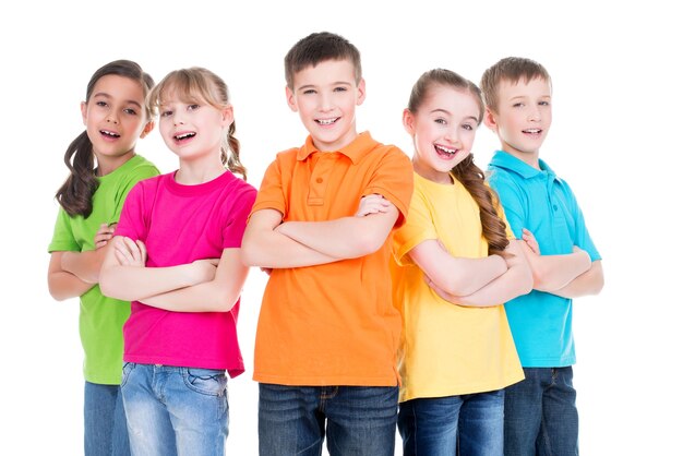 白い背景の上に一緒に立っているカラフルなTシャツの腕を組んで笑顔の子供たちのグループ。