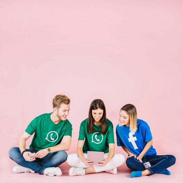 Group of smiling friends looking at digital tablet