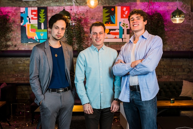 group of smiling male friends in bar