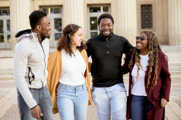 Group of smiling people under sunlight with a building on the blurry