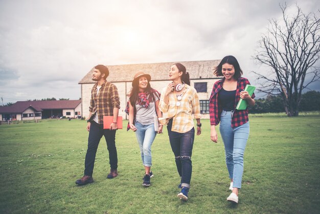 Group of student walking through the park after class. Enjoy talking together.