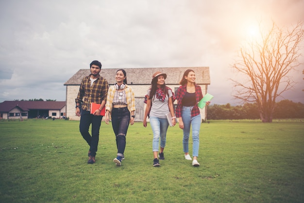 Group of student walking through the park after class. Enjoy talking together.