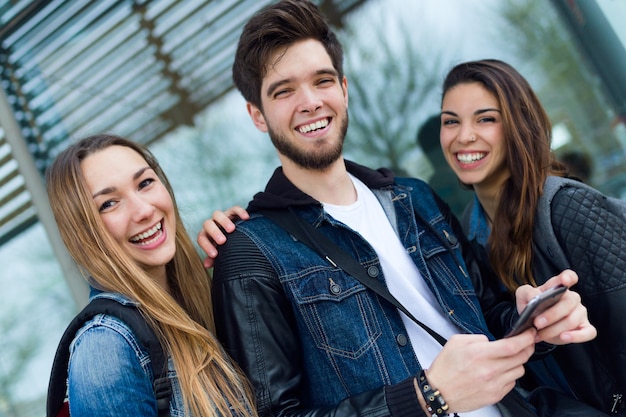 Group of students having fun with smartphones after class.