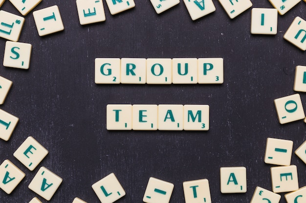 Group team scrabble letters over black background