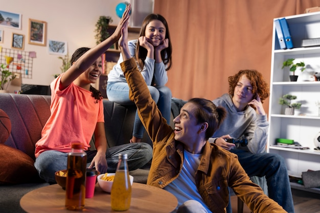 Group of teenage friends playing games at home together