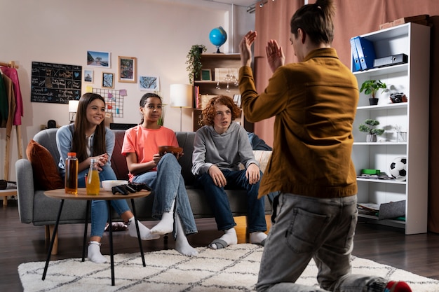 Group of teenage friends playing games at home together