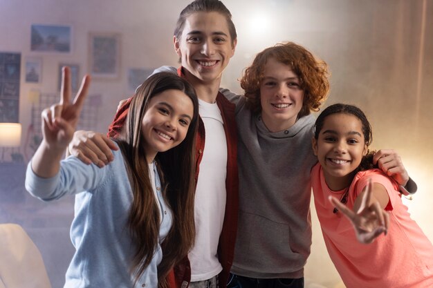 Group of teenage friends posing together at home during party