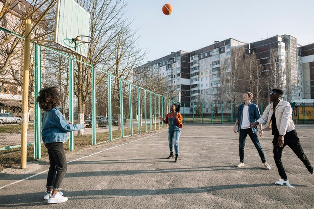 Группа подростков, играющих в баскетбол вместе