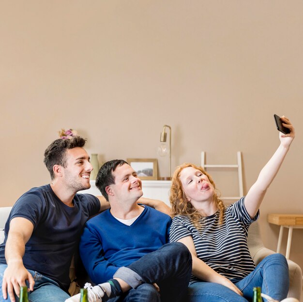 Free photo group of three friends at home taking a selfie