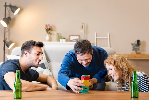 Group of three friends playing games at home