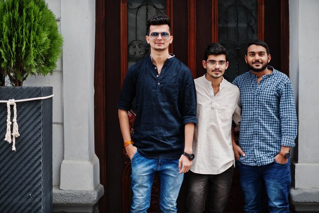 Group of three indian mans wear on casual clothes posed outdoor at street of India