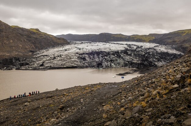 寒い時期にアイスランドのSolheimajokull氷河を旅する旅行者のグループ