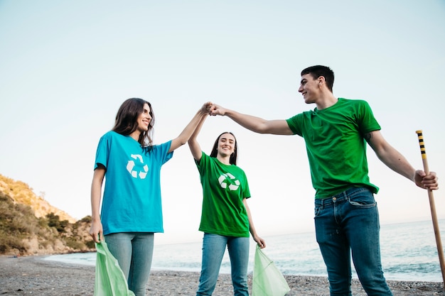 Group of volunteers collecting trash at the beach with teamwork concept