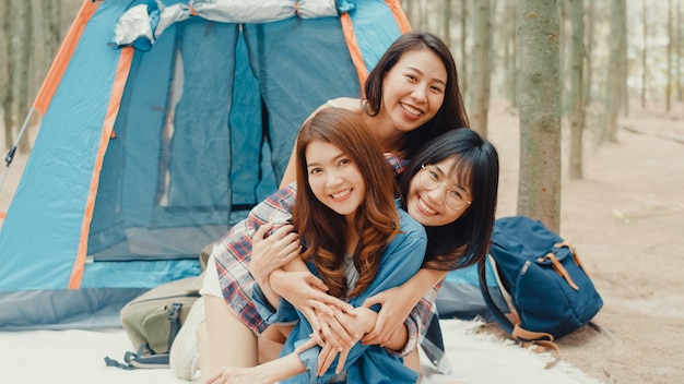 Группа молодых азиатских друзей-кемперов в кемпинге рядом с расслабляющим отдыхом в лесу