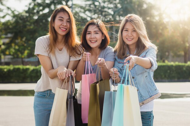 Группа молодых азиатских женщин, покупки на открытом рынке с сумок в руках