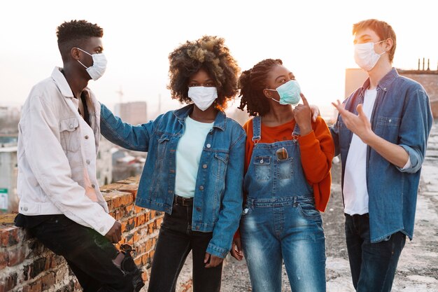 Group of young friends hanging out with medical masks