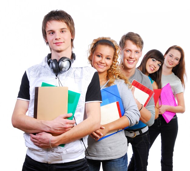 Group of young joyful students standing with book and bags
