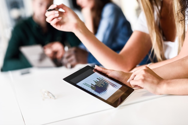 Free photo group of young men and woman coworking with tablet computer