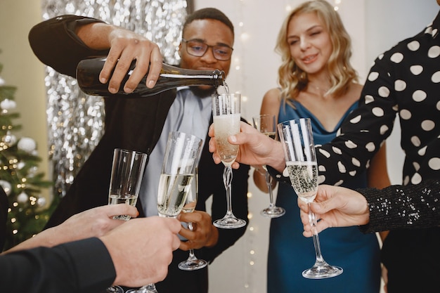 Group of young people celebrating new year. Friends drinks champagne.