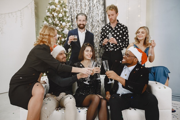Foto gratuita gruppo di giovani che celebrano il nuovo anno. gli amici bevono champagne.