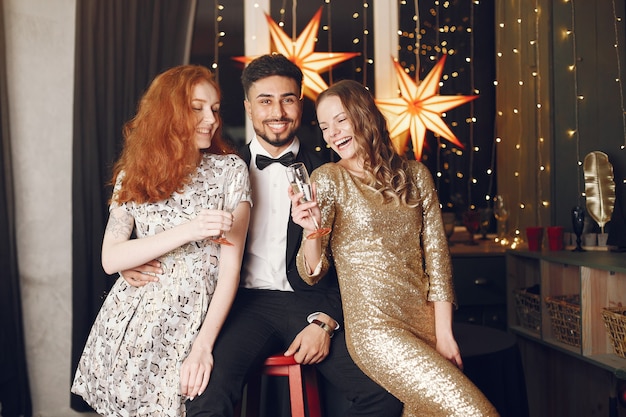 Group of young people celebrating new year. Women with indian man.