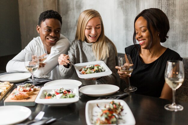 Group of young people enjoying dinner together