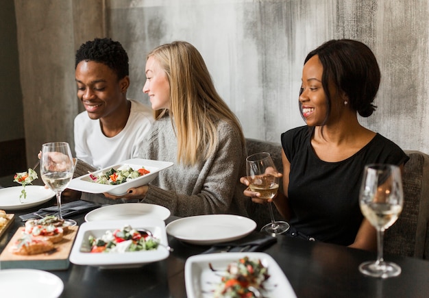 Group of young people enjoying dinner and wine