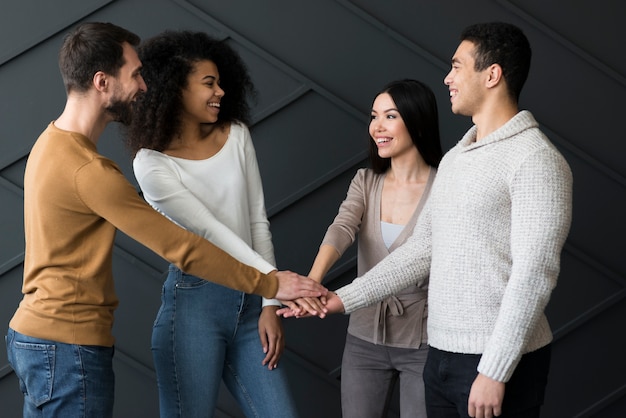 Group of young people holding hands together